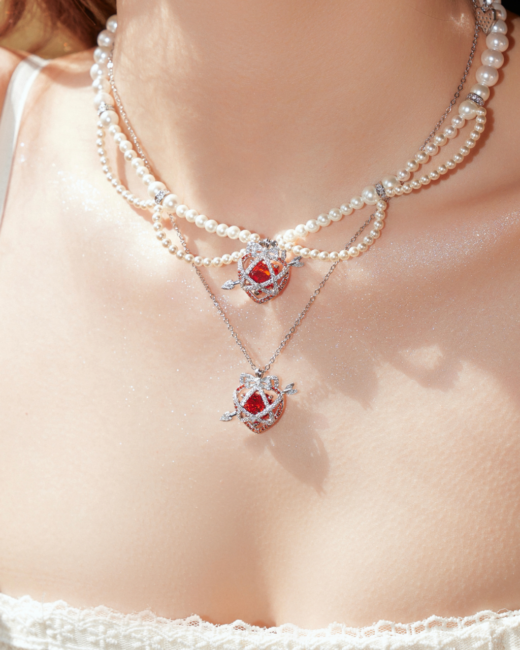Layered pearl and ruby pendant necklaces worn on the neck